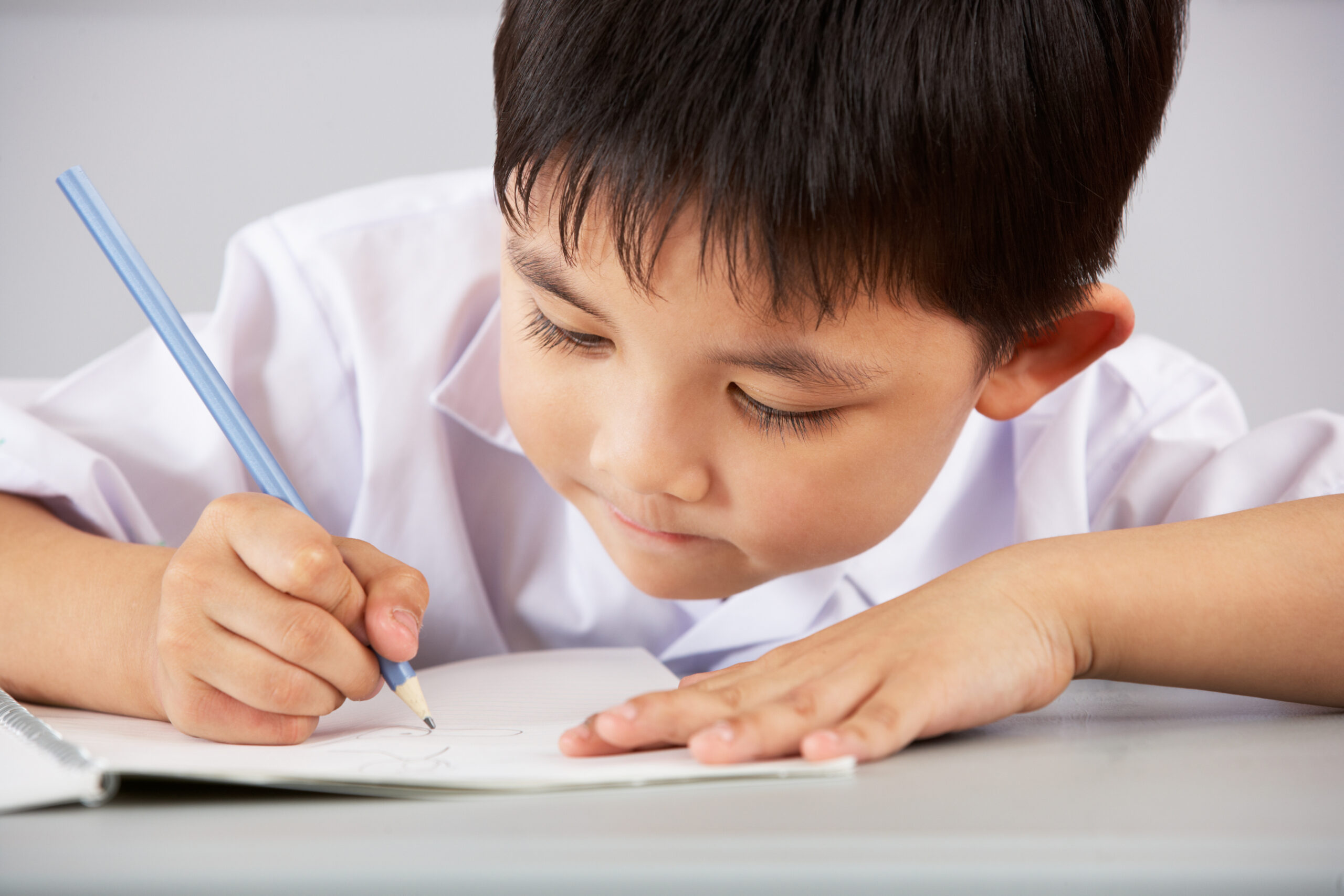 Male Student Working At Desk In Chinese School Classroom - Connectprep ConnectPrep: Tutoring that elevates your grades