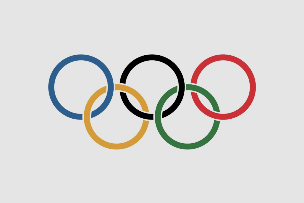 The Olympic rings symbol featuring five interlocking rings in blue, black, red, yellow, and green on a light gray background.