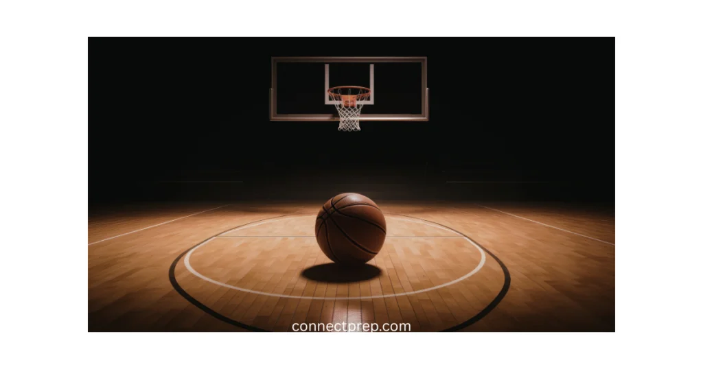 A basketball rests at the center of an empty, well-lit indoor court, with a hoop and backboard visible in the background. The image features the text connectpreps.com at the bottom.